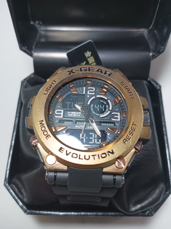 A large, rugged men's wristwatch with a metallic gold and bronze finish, displayed in an open black box. the watch features multiple buttons and a digital display. Model Number: XG985 100% ORIGINAL Authentic dari Hong Kong !!! Dual Time movement.