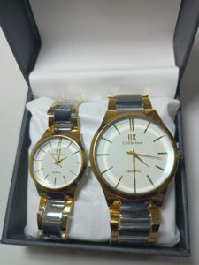 Pair of gold and silver watches in a box.