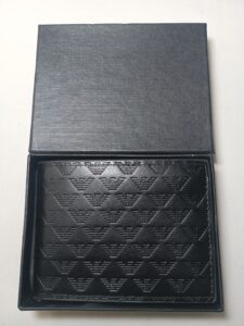 A black leather wallet neatly placed inside a box, ready to be used for storing money and cards.